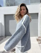 Sweater de tejido de punto en color gris con detalles de bordes en color blanco, de corte holgado y mangas largas.