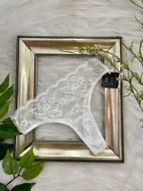 Vedetina de encaje blanco con elástico fino en cintura y piernas.