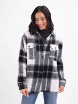 Sobrecamisa de franela con estampado de cuadros grandes en tonos blanco y negro. Presenta cuello camisero, cierre frontal con botones, mangas largas con puños abotonados y bolsillos frontales con solapa.