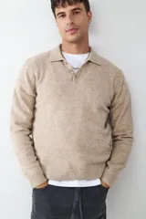 Sweater de punto con cuello polo y cierre frontal de botones. Presenta un diseño de manga larga con puños y ruedo acanalados.