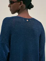 Cardigan largo azul tejido en jersey con lurex, con bolsillos en el frente y detalle en cobre con logo.