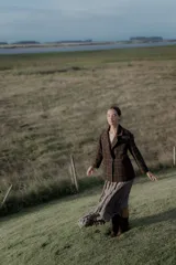 Chaqueta corta con diseño de estampado cuadrillé en tonos chocolate y rosa, con cuello camisero y cierre frontal de botones.