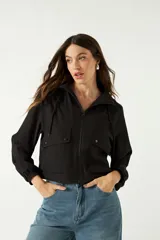 Campera deportiva corta color negro, con capucha ajustable y bolsillos frontales.