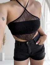 Top negro de encaje con tirantes finos cruzados en la espalda.