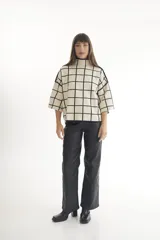 Sweater de punto con cuello alto y manga corta, con estampado de cebra en blanco y negro.