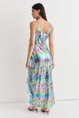 Vestido largo con estampado floral multicolor, escote en V, breteles finos y volados asimétricos.