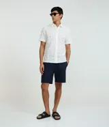 Bermuda recta de playa para hombre en algodón texturizado, de corte recto con bolsillos. Presenta un diseño con sutiles rayas y textura.