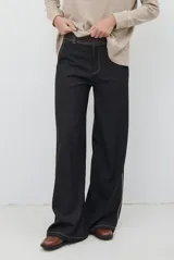 Pantalon de corte recto y tiro medio, confeccionado en tela de jean color azul oscuro. Presenta costuras a contratono en color blanco y una cintura con detalle de tela a cuadros.