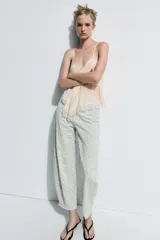 Jeans tiro alto corte tapered de Zara Woman Collection, confeccionados en denim con estampado floral y rayas verticales sutiles. Presenta diseño de cinco bolsillos, trabillas para cinto y cierre frontal con cremallera y botón metálico.