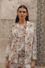 Blazer gris con estampado de besos, lobos y la palabra 'Amour', de corte clásico con solapas y cierre frontal con botones.