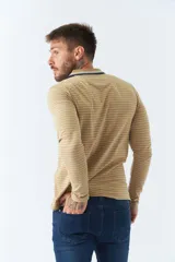 Chomba manga larga color beige con rayas horizontales blancas, cuello polo con borde azul marino y logo bordado en el pecho.