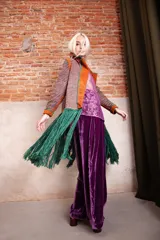 Tapado artesanal tejido en telar con lana teñida, presenta solapas y detalles en cuero natural con terminaciones de pasamanería. Diseño de corte amplio y textura tejida.