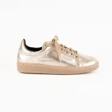Zapatillas urbanas de cuero metalizado en color dorado, con suela plana cosida en tono tostado y cordones al tono.