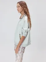 Buzo de algodón con cuello alto y cierre frontal parcial. Presenta bolsillos laterales con cierre y cuello con interior en contraste. Diseño de corte oversize.