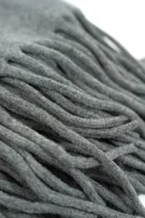 Poncho gris liso con flecos largos en el borde superior.