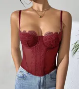 Corset de encaje con transparencias, escote corazón y tirantes finos ajustables. Presenta varillas verticales que estructuran la prenda y detalle de encaje festoneado en el borde superior.