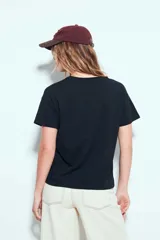 Remera blanca de manga corta, con estampa frontal en color marrón con motivos de café y la leyenda 'Slow Mornings Club'.