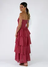 Vestido largo sin tirantes, color rojo, con cuerpo ajustado de nido de abeja y falda larga con múltiples volantes escalonados con bordes deshilachados.
