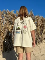 Remera color crema de algodón con estampa en la espalda de un paisaje playero con el texto "Chema Sure Chate et la mer".