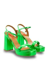 Sandalia alta dorada con plataforma y taco ancho. Posee una tira fina en la parte delantera y una tira ajustable con hebilla en el tobillo.