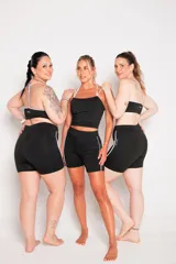 Calza corta negra de lycra suplex con cintura alta y una franja vertical blanca en el lateral.