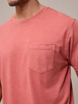 Remera básica de cuello redondo con bolsillo frontal, confeccionada en algodón con efecto de lavado gastado.