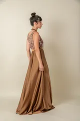 Vestido largo rojo con cuerpo de lentejuelas y falda de satén con caída fluida. Presenta escote redondo, sin mangas y un lazo en la cintura.