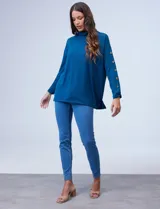 Polera negra de tejido soft con cuello alto y mangas largas con aplique de botones.