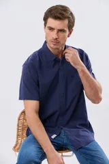 Camisa de manga corta confeccionada en mezcla de lino y algodón, color beige, con cuello camisero abotonado, bolsillo frontal en el pecho y cierre de botones.
