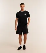 Bermuda deportiva masculina de corte holgado, color negro, con cintura elástica y cordón ajustable. Presenta un diseño minimalista con bolsillo trasero.