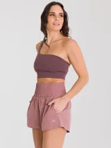 Top deportivo de un hombro con diseño ajustado, confeccionado en tejido técnico con soporte bajo y almohadillas removibles.