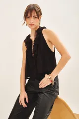 Top negro sin mangas con escote profundo, detalle de volados frontales y lazos para anudar en el cuello.
