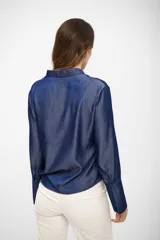 Blusa de tela tipo denim en color azul noche, con escote en V y mangas largas con puños anchos abotonados.