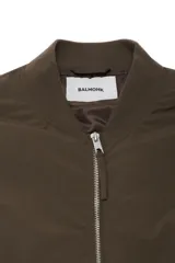 Campera tipo bomber acolchada en color verde militar, con cuello redondo, cierre frontal de cremallera metálica y bolsillos laterales con cierre. Presenta puños y bajo elásticos para un ajuste cómodo.