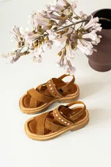 Sandalias de cuero marrón con textura de cocodrilo, diseño de tiras cruzadas con tachas metálicas plateadas y suela track negra de plataforma.