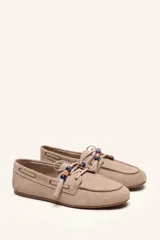 Mocasín estilo náutico de gamuza marrón, con cordones de cuero, borla decorativa y cuentas de colores en el empeine.