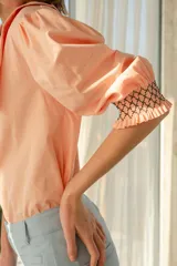 Blusa color salmón con cuello XL, mangas abullonadas y bordado elastizado en los puños.