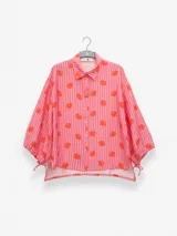 Camisa de manga larga color rosa con rayas verticales rojas y estampado de flores rojas. Con cuello camisero, puños elastizados y lazos regulables en los costados del ruedo.
