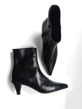 Bota corta de cuero negro con punta fina y taco bajo tipo kitten heel.