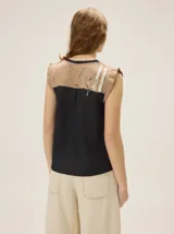 Remera sin mangas de algodón con elastano, color negro con detalles en tono tostado en los hombros, corte recto y diseño básico.