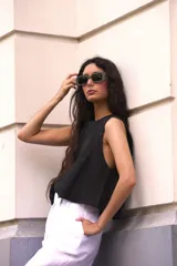 Top sin mangas de lino color blanco, con cuello redondo y silueta amplia de corte recto.
