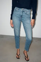 Jeans mom fit de tiro alto color negro con efecto lavado, diseño de cinco bolsillos y corte tobillero.