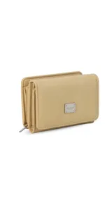 Billetera corta de símil cuero color beige, con cierre a presión y placa metálica decorativa. Cuenta con múltiples compartimentos internos para tarjetas, visor y billetes, además de un compartimento posterior con cierre.