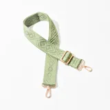 Correa de tela tejida color verde con diseño geométrico en relieve y herrajes metálicos color cobre.