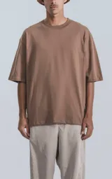 Remera de corte holgado y diseño relajado, con cuello redondo y mangas cortas con hombros caídos. Presenta un largo a la altura de la cadera.
