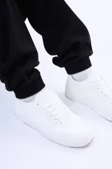 Pantalón cargo de gabardina color negro, con bolsillos laterales tipo cargo, cintura elástica con cordón ajustable y puños elásticos en los tobillos.