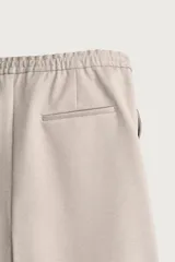 Bermuda regular fit de tejido elástico color blanco, con cintura elástica ajustable mediante cordón, bolsillos delanteros y bolsillos traseros de vivo.