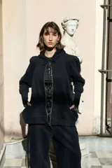 Campera deportiva oversize con capucha, cierre metálico frontal y bolsillos laterales. Presenta mangas raglán con volumen pronunciado y puños largos de rib elastizado. Confeccionada en felpa de algodón, con cordones regulables a tono y terminaciones metálicas.