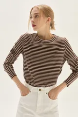 Jean de mujer color blanco, tiro alto, con pierna ancha y corte acampanado. Presenta costuras verticales marcadas en el frente de las piernas.