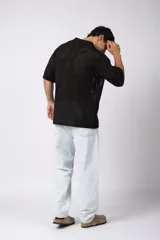 Camisa de punto calado en color beige, de manga corta y corte relajado. Presenta cuello tipo bowling, cierre frontal con botones al tono y una estructura liviana y respirable confeccionada en algodón.